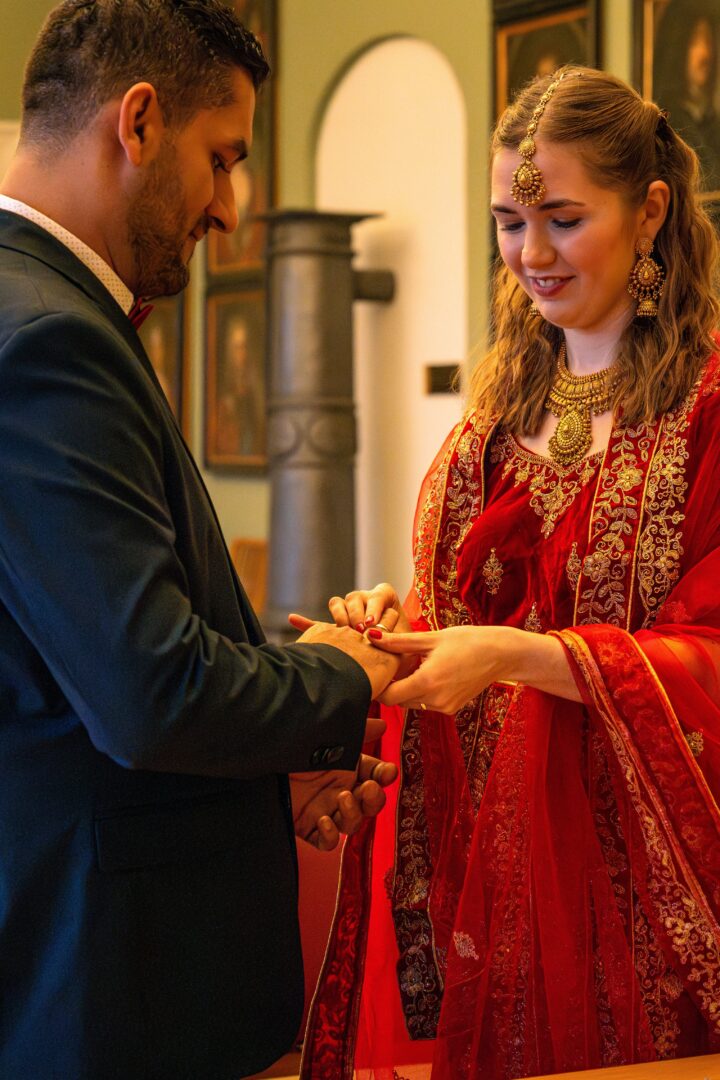 Bride placing the wedding ring on the groom’s finger during their intimate town hall wedding ceremony.