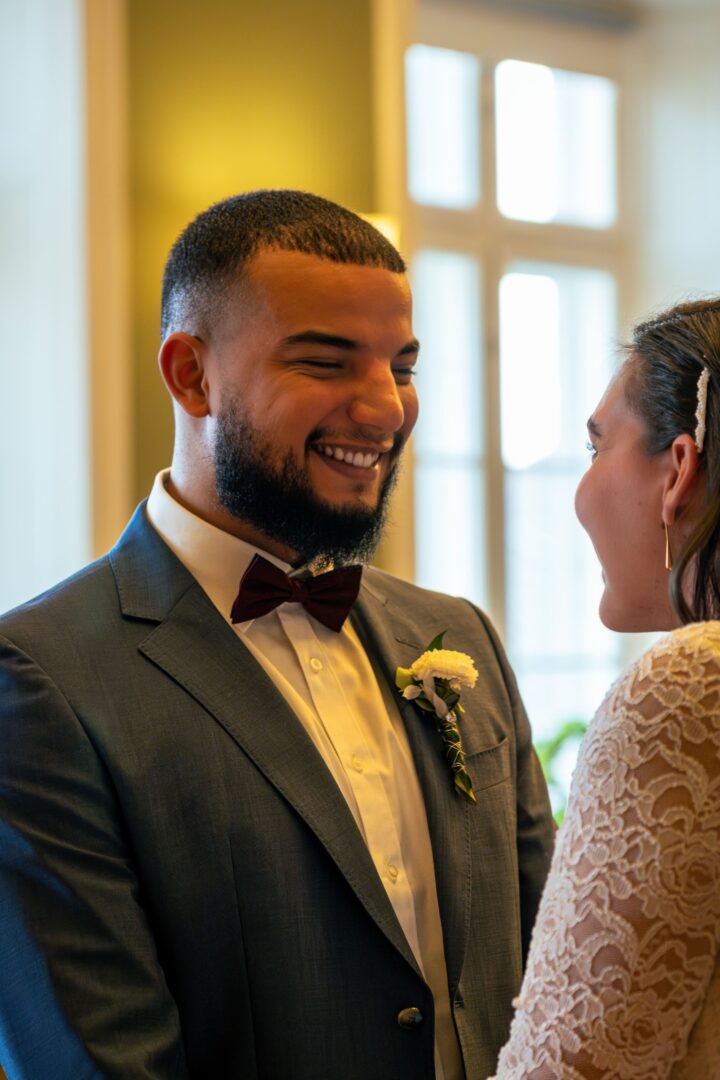 Couple looking at each other and smiling in the town hall, sharing a joyful moment.