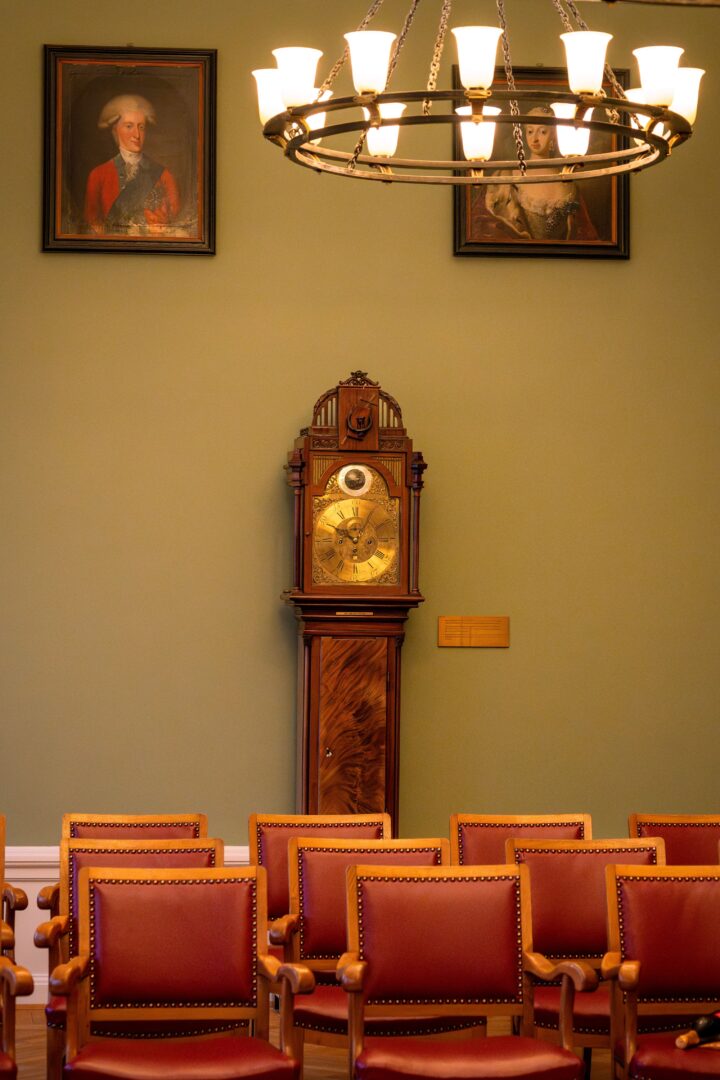 Detail shot of the grandfather clock and guest seating in the town hall, showcasing the elegant and timeless setting for the wedding ceremony.