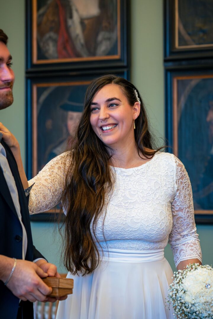 International couple in the town hall, bride smiling and holding a beautiful flower bouquet in her hand.
