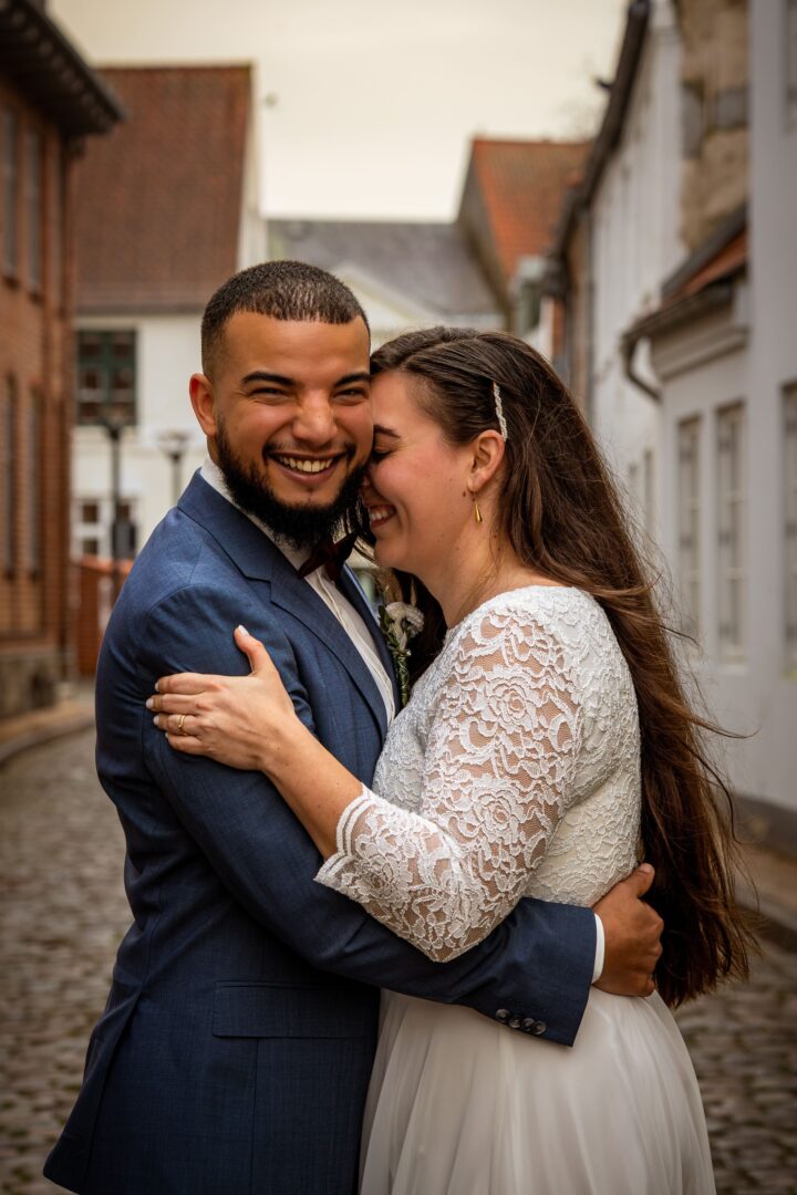 A beautiful international couple hugging, laughing, and holding each other closely.