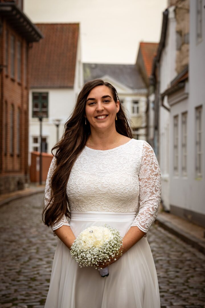Portrait of the bride smiling in a charming, historic setting, radiating happiness and joy.