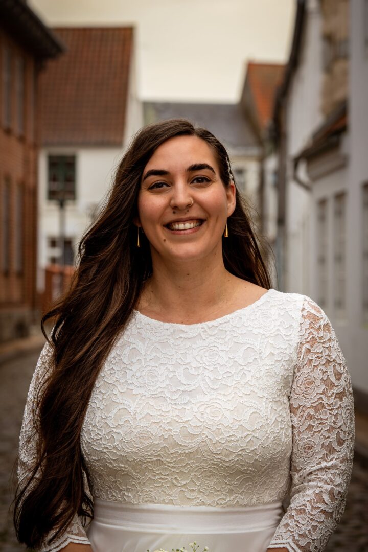 Portrait of the bride smiling on an old street, radiating happiness and joy.