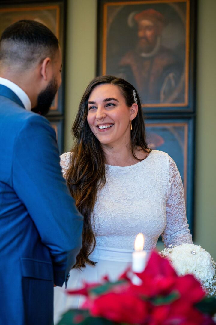Bride smiling at the groom in the town hall, radiating love and happiness.