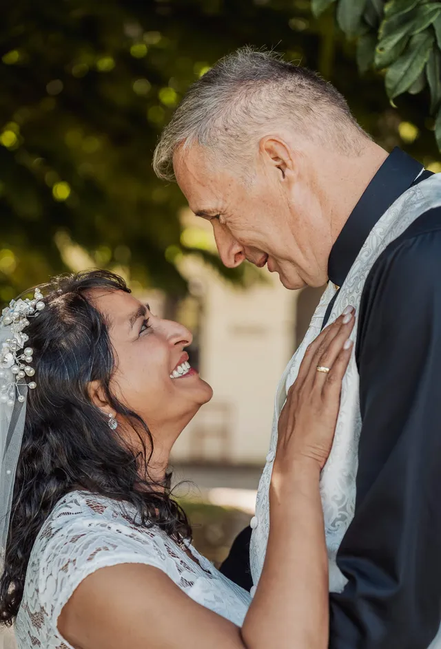 couple laughing together under the trees after their wedding ceremony