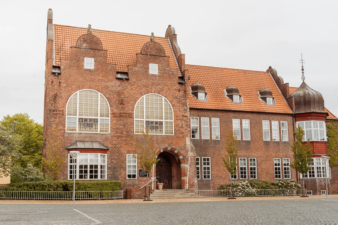 The red brick front of Jomfrustien 8 in Tønder, with its arched doorway onto the cobbled square